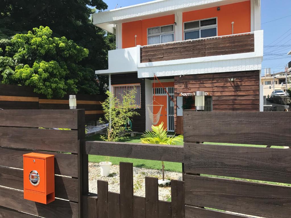 a house behind a fence with an orange mailbox at South Island in Itoman