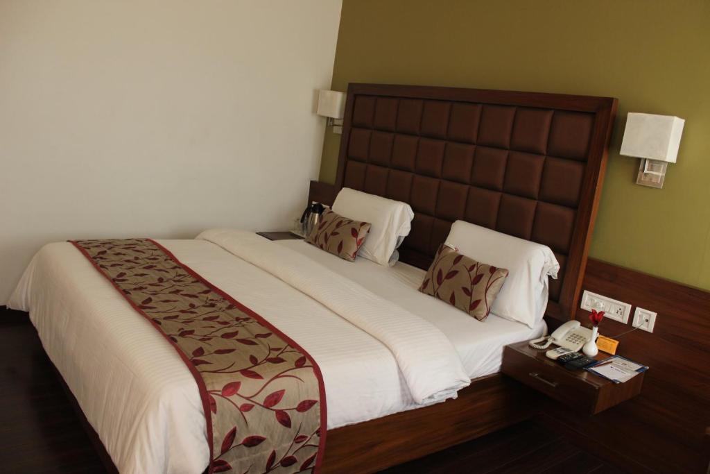 a bedroom with a large bed with a telephone at Hotel Stay Inn in Hyderabad
