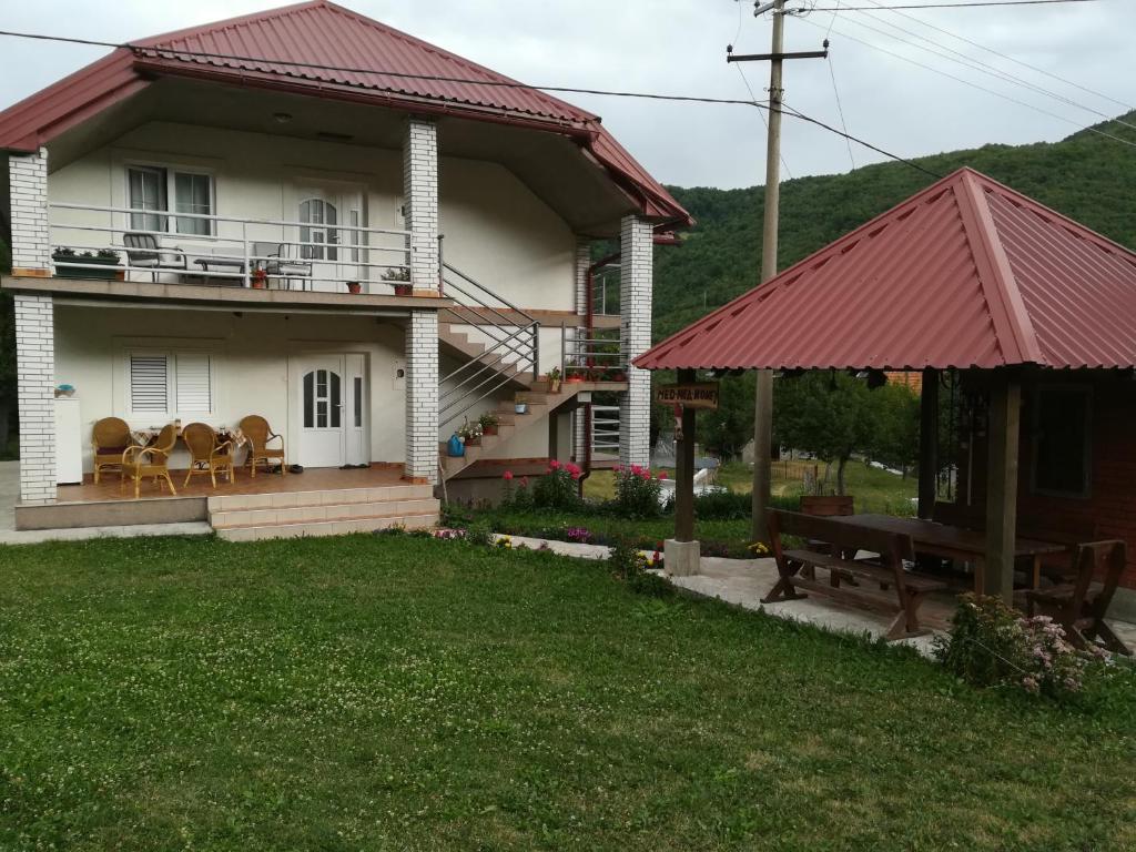 une maison avec un toit rouge et une table de pique-nique dans l'établissement Apartment Mitric, à Plužine