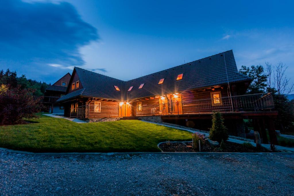 a log cabin with lights on the side of it at Relax Apartmany in Oščadnica