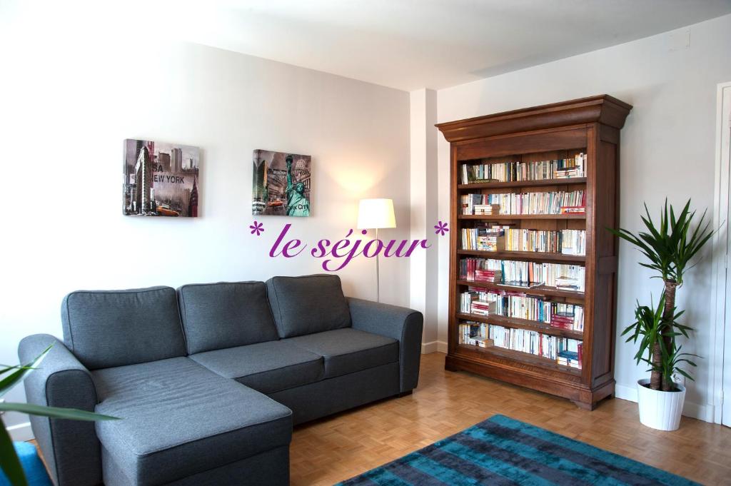 ein Wohnzimmer mit Sofa und Bücherregal in der Unterkunft Appart Confort Centre Parking Gratuit in Vichy