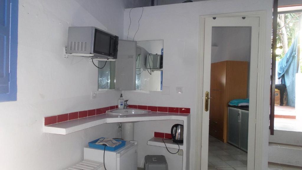 a small kitchen with a sink and a microwave at Casa Rural La Fuensanta in Mojácar