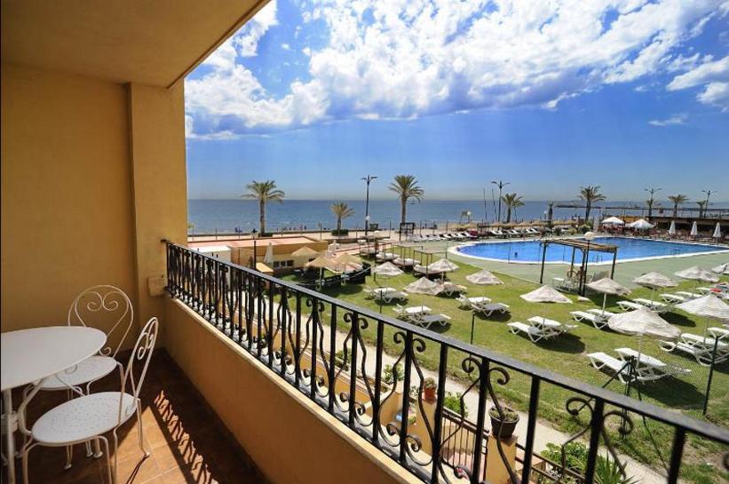 a balcony with a view of a pool and a resort at First line apartment in Alboraya