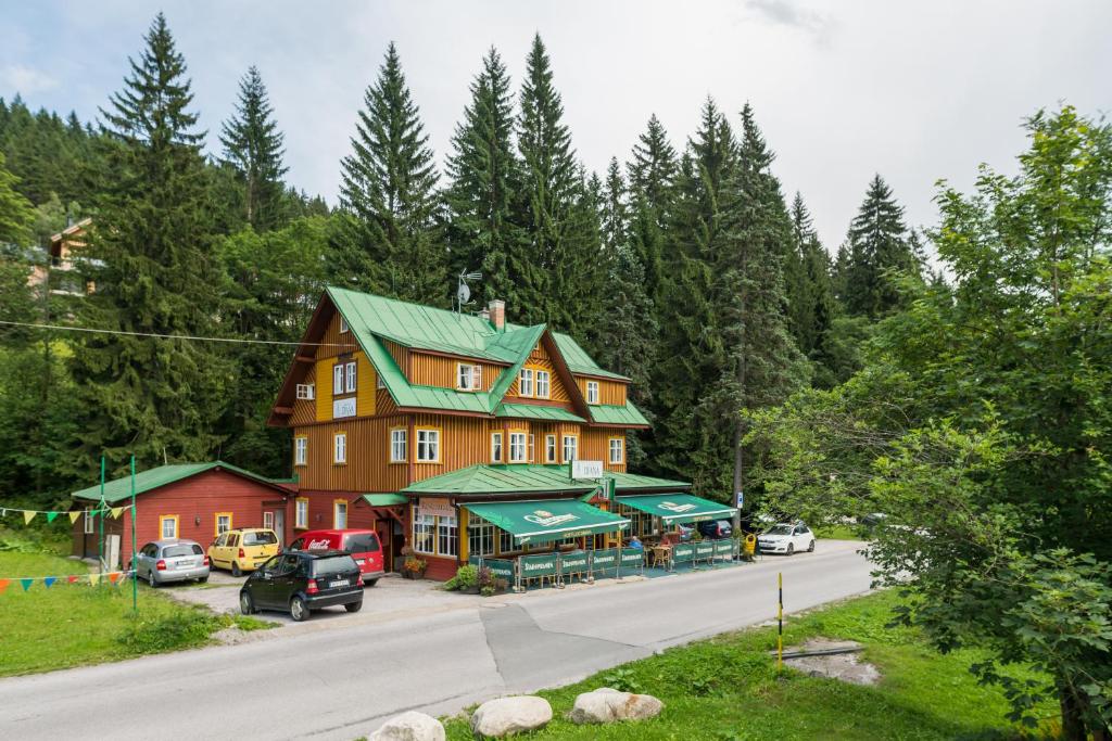 a large house with a green roof on the side of a road at Hotel Diana in Špindlerův Mlýn