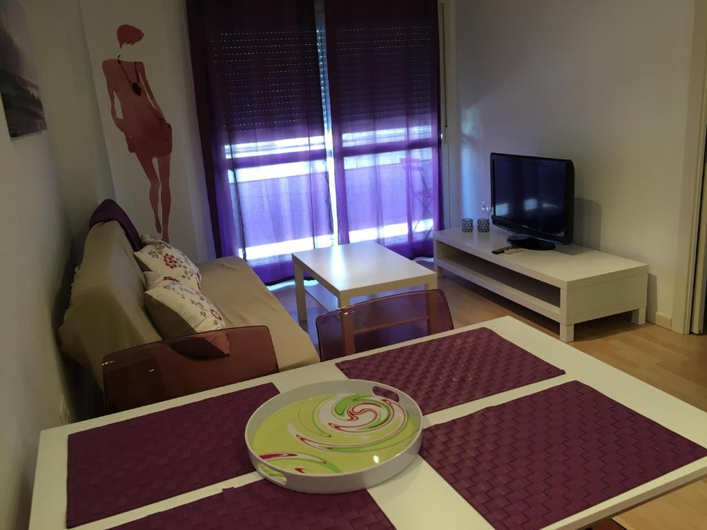 Televízia a/alebo spoločenská miestnosť v ubytovaní Apartaments Muntaner I