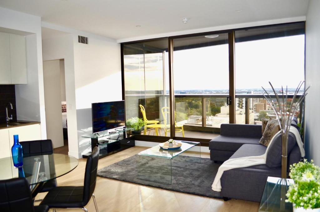 a living room with a couch and a glass table at VUEonKW in Adelaide