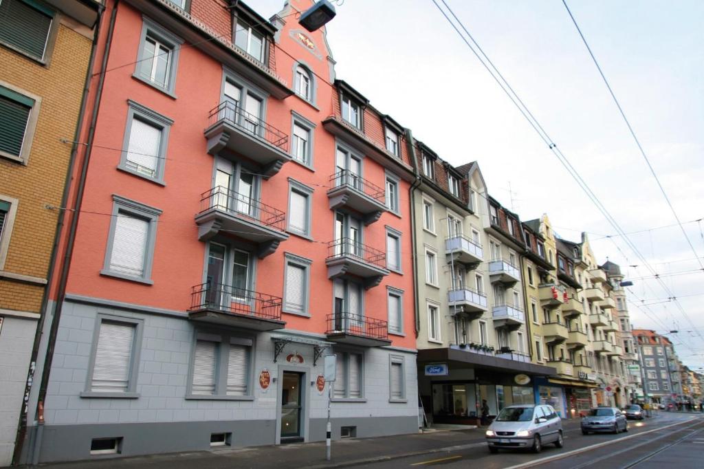 un edificio en una calle de la ciudad con coches aparcados delante en Swiss Star Marc Aurel - Self Check-In en Zúrich