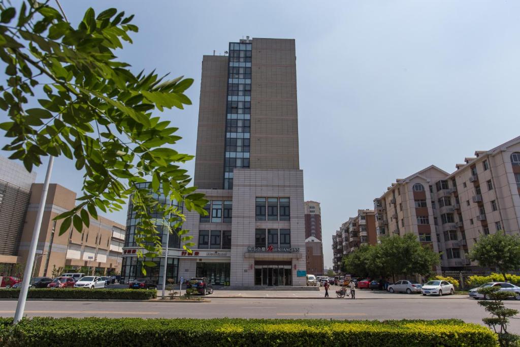a tall building in the middle of a street at Jinjiang Inn Tianjin South Railway Station in Tianjin