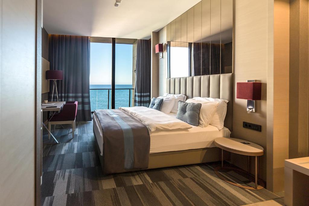 a bedroom with a bed with a view of the ocean at Vista Hotel in Mezitli