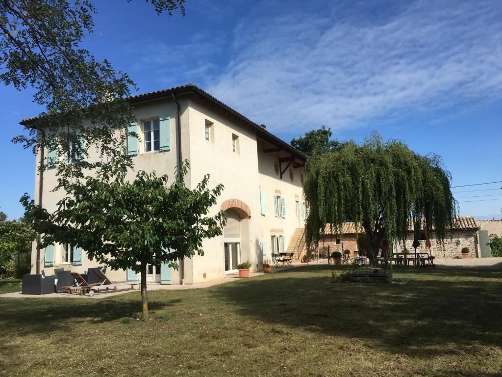 a large white house with a tree in the yard at Coeur De Beaujolais in Corcelles-en-Beaujolais