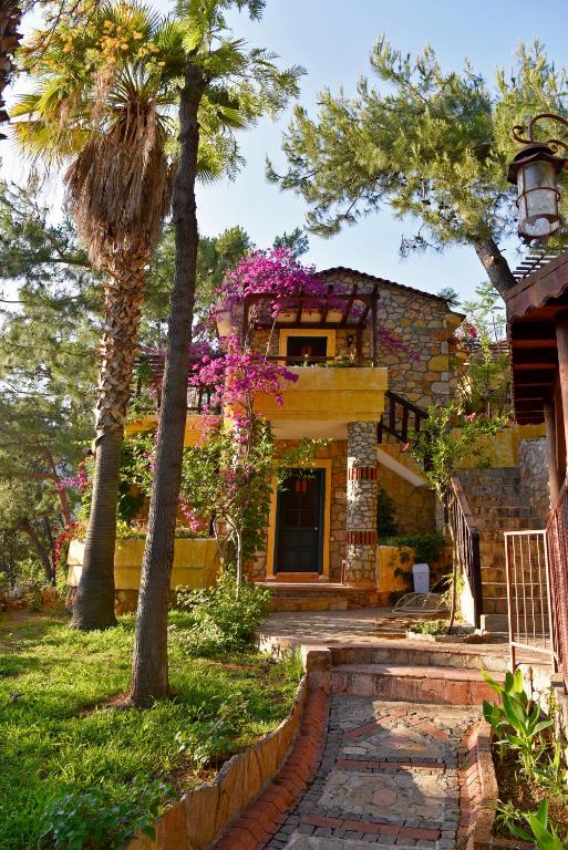 a house with trees and flowers in front of it at Symbola Oludeniz Beach Hotel in Oludeniz