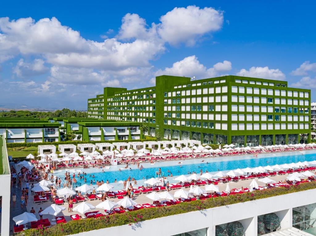 a large pool with chairs and umbrellas in front of a building at Adam & Eve - Adult Only in Belek