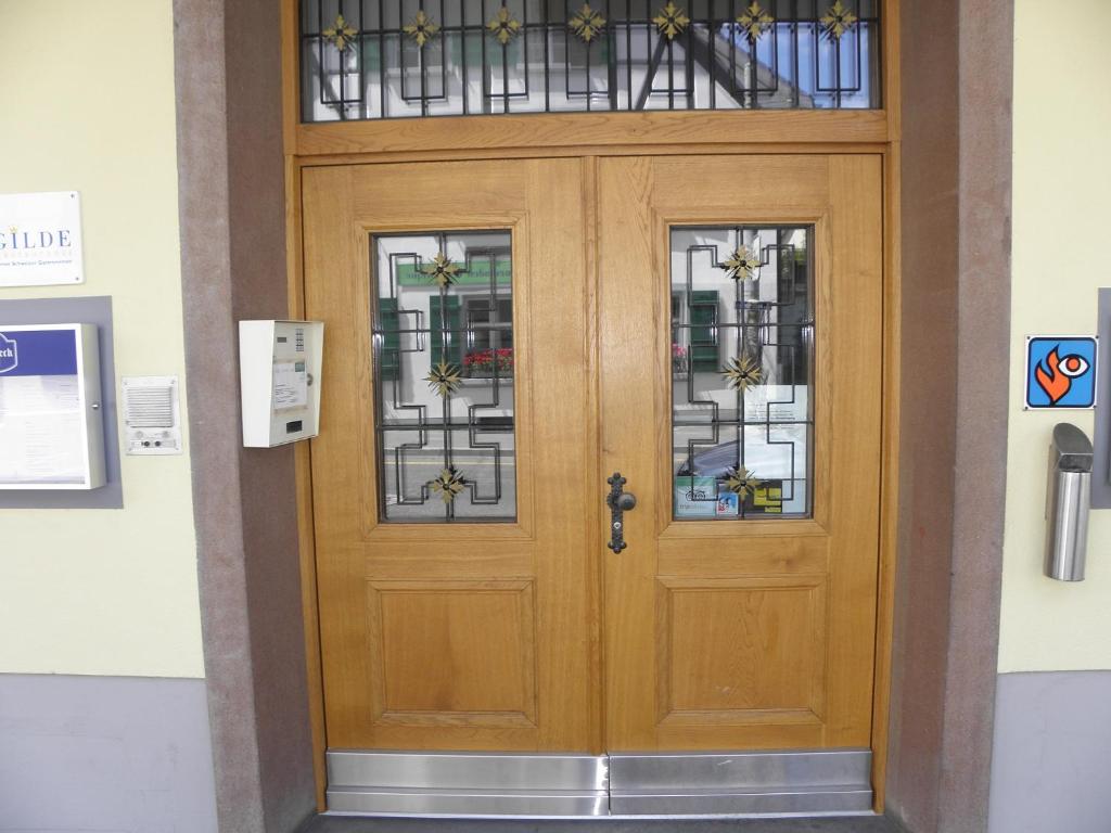 a wooden door with a cross and stained glass at Hotel Rössli in Basel
