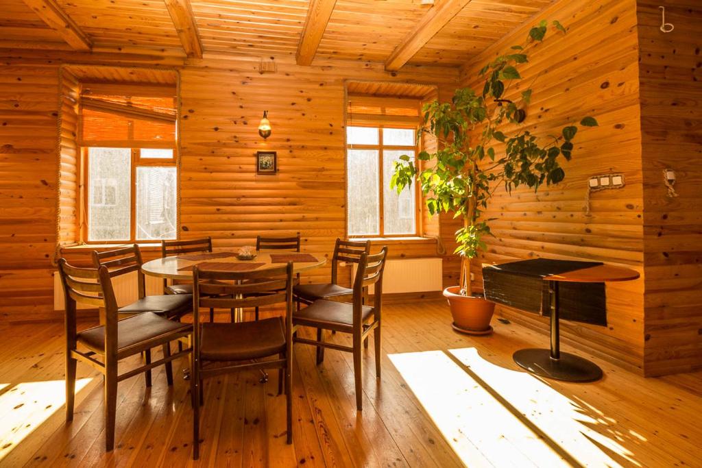 comedor con paredes de madera, mesa y sillas en Alevi Holiday Home with Sauna en Tallin