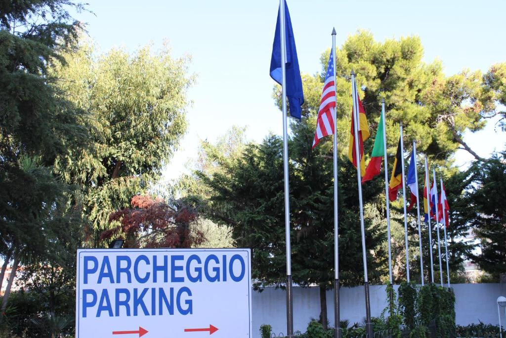 a sign in front of a bunch of flags at Vittoria Parc Hotel in Bari