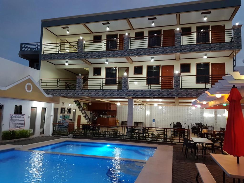 un hotel con piscina frente a un edificio en Hotel Georgina, en Maitim
