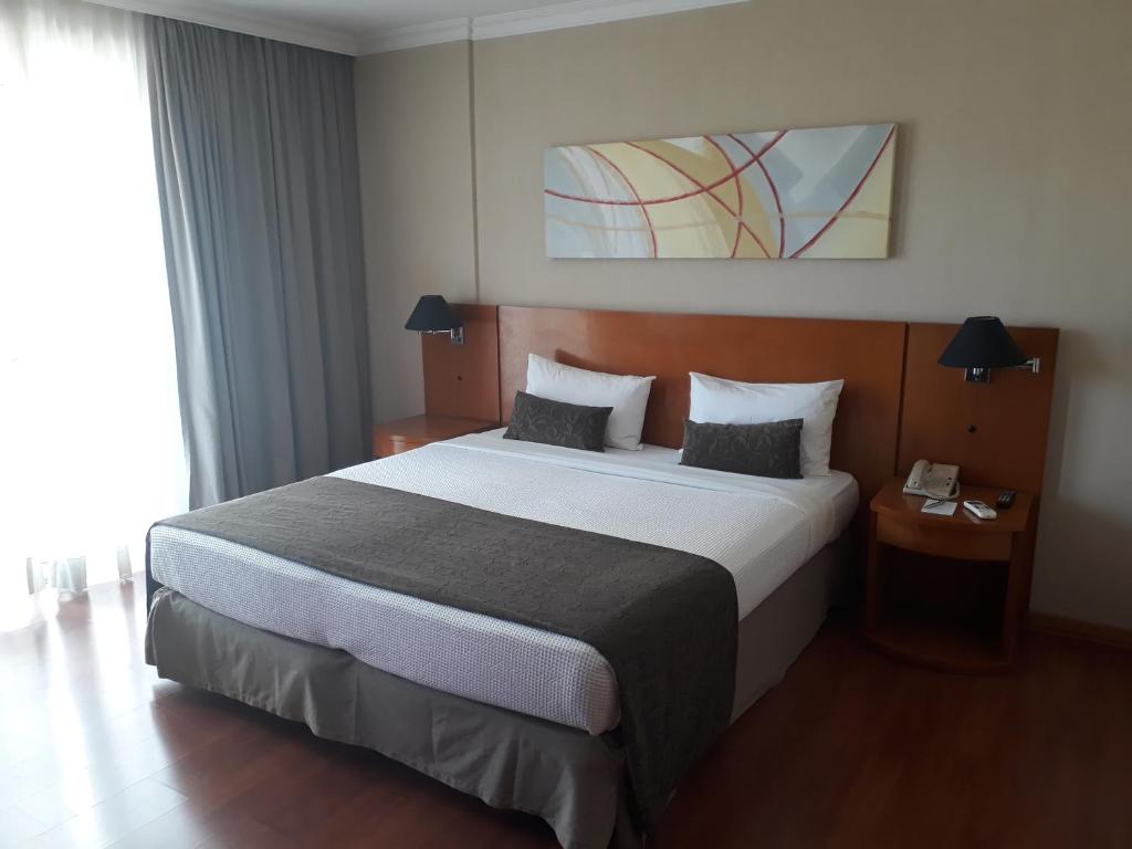1 dormitorio con 1 cama grande en una habitación de hotel en Barra First Class, en Río de Janeiro