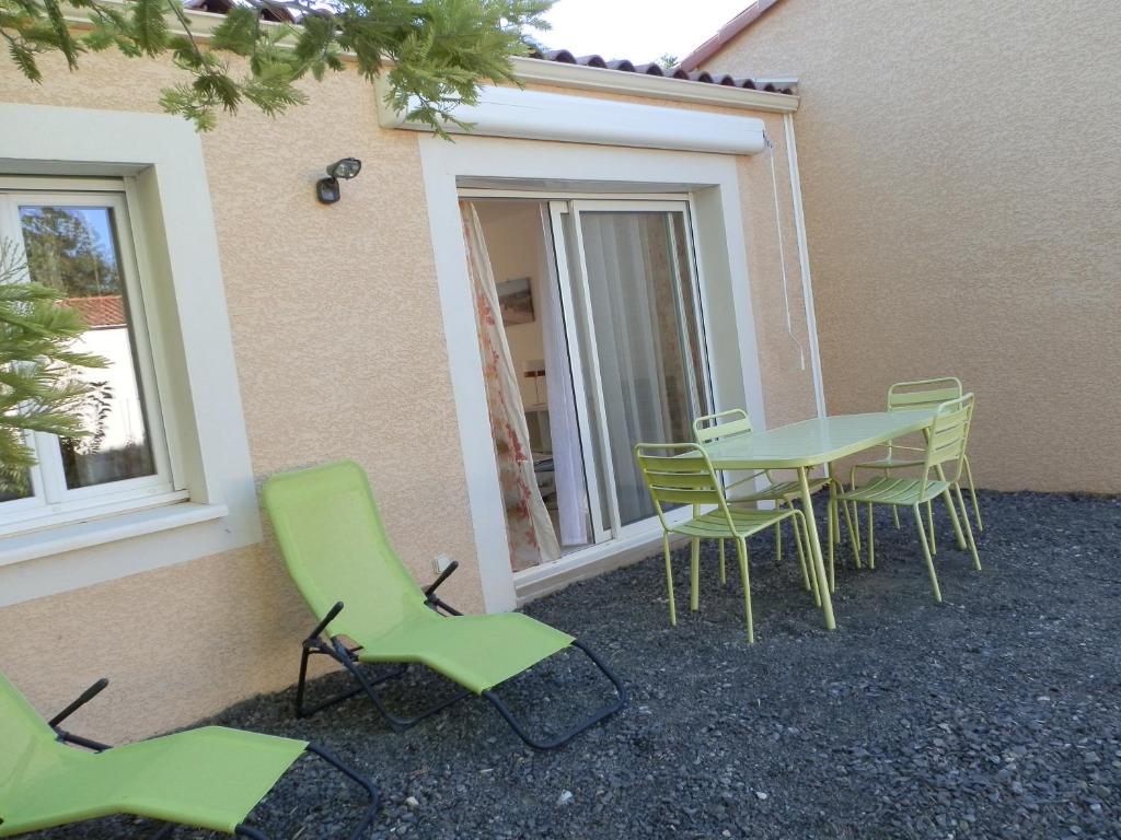 un patio avec une table et des chaises à côté d'un bâtiment dans l'établissement Maison indépendante, à Salinelles