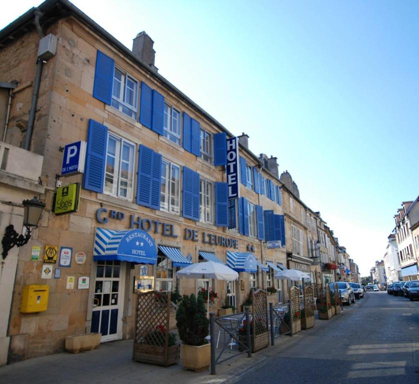 un bâtiment avec volets bleus dans une rue de la ville dans l'établissement Logis Grand Hôtel De L'Europe, à Langres