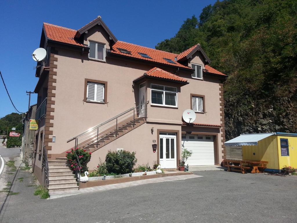 a house with a garage and a driveway at Rooms Odmaralište Jablan in Senj