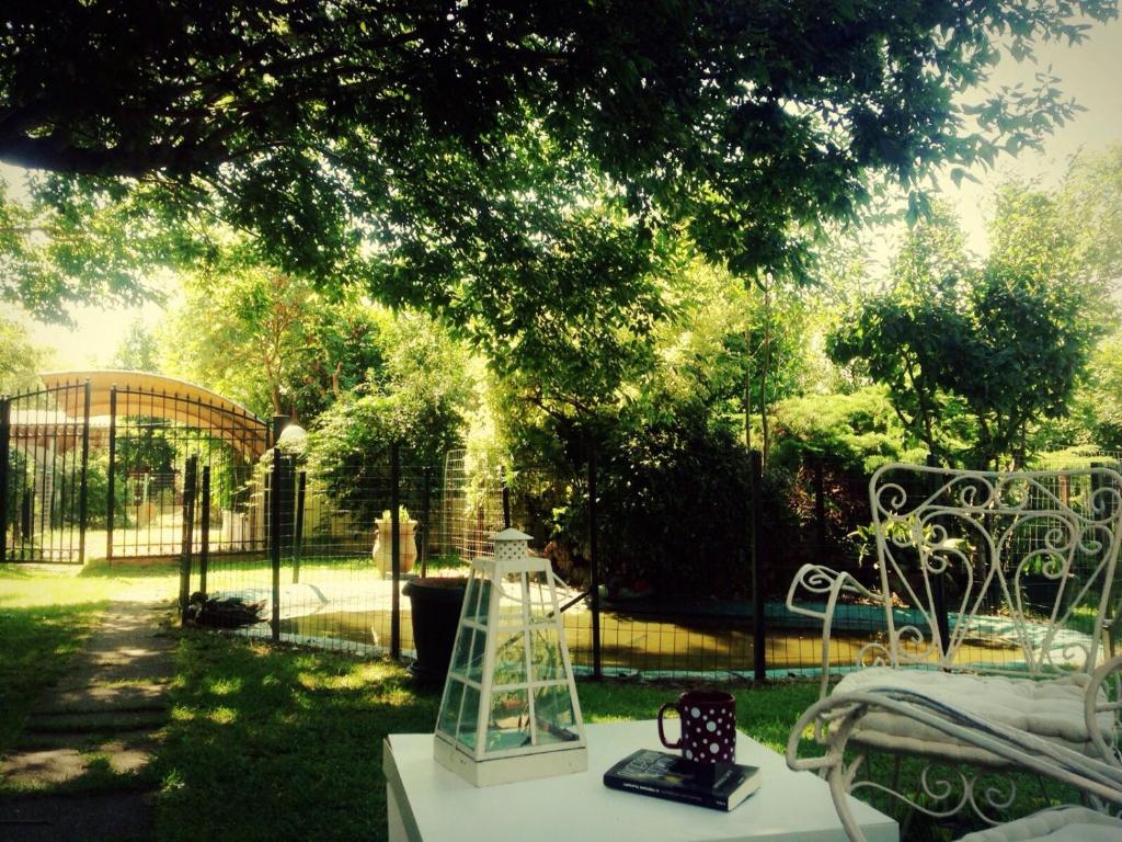 a table with a clock on it next to a fence at Seaside Cottage in Paralia Katerinis