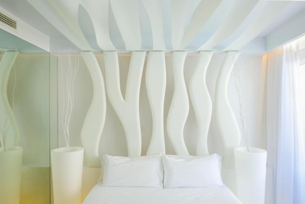 a bedroom with a bed with two white pillows at Apartamentos Portu Saler in Es Pujols