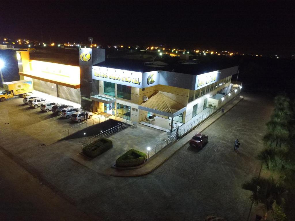 un bâtiment avec des voitures garées dans un parking la nuit dans l'établissement Entre Rios Hotel, à Picos