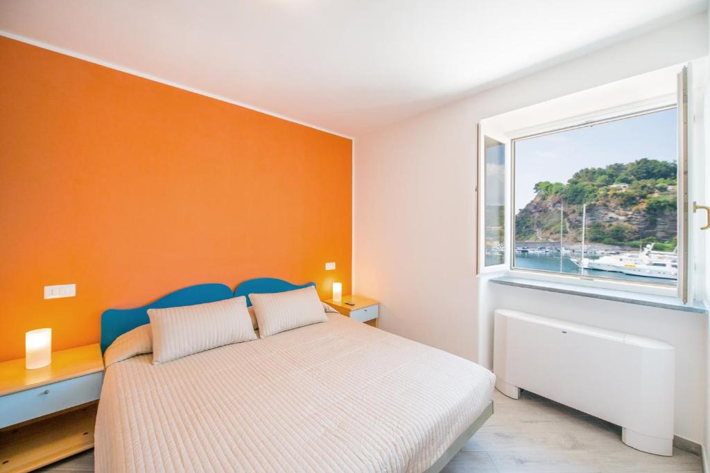 Schlafzimmer mit einem Bett und einem Fenster in der Unterkunft Hotel Ristorante Crescenzo in Procida