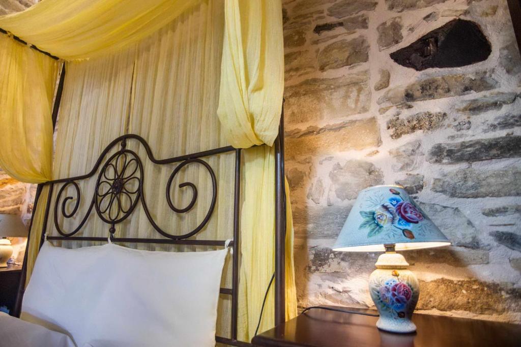 a bedroom with a bed and a lamp on a table at Vouno Village Apartments in Vounós