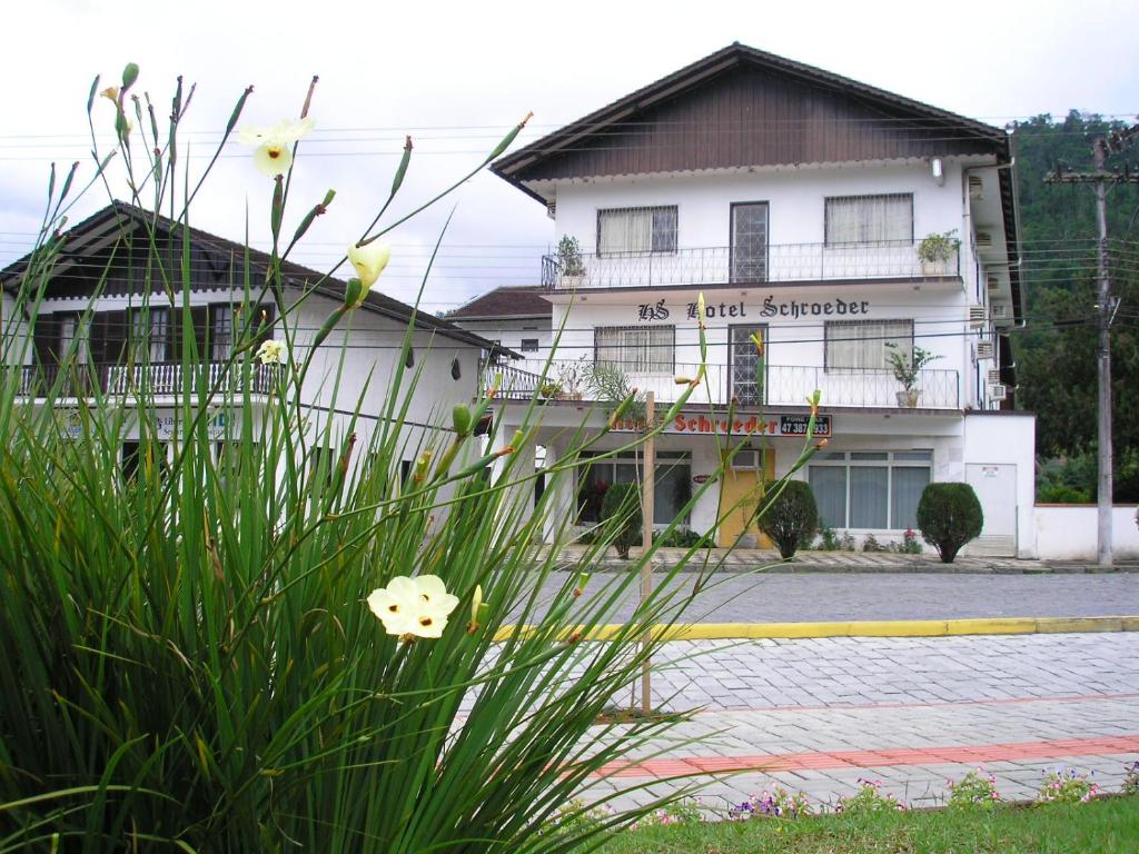 un bâtiment avec une fleur devant lui dans l'établissement Hotel Schroeder, à Pomerode