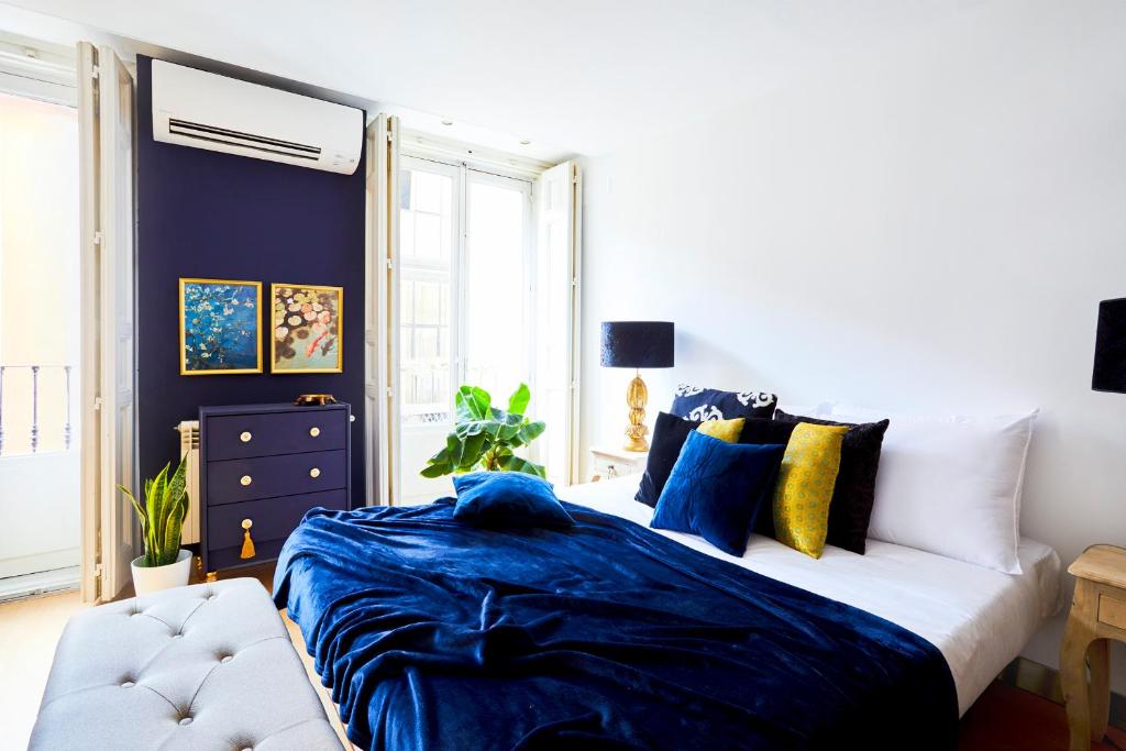 マドリードにあるRoyal Palace Gran Via Boutiqueのベッドルーム1室(青いシーツとソファ付)