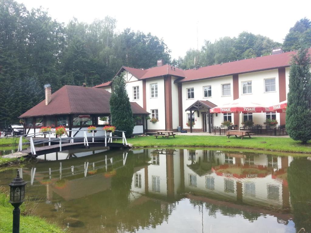 a large building with a lake in front of it at Uroczysko in Jastrowie