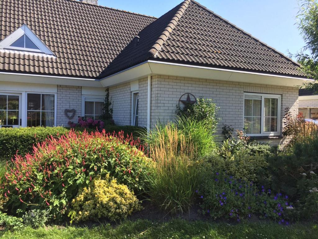 ein Haus mit blühenden Pflanzen im Hof in der Unterkunft Lonestar Appartement in Burgh Haamstede