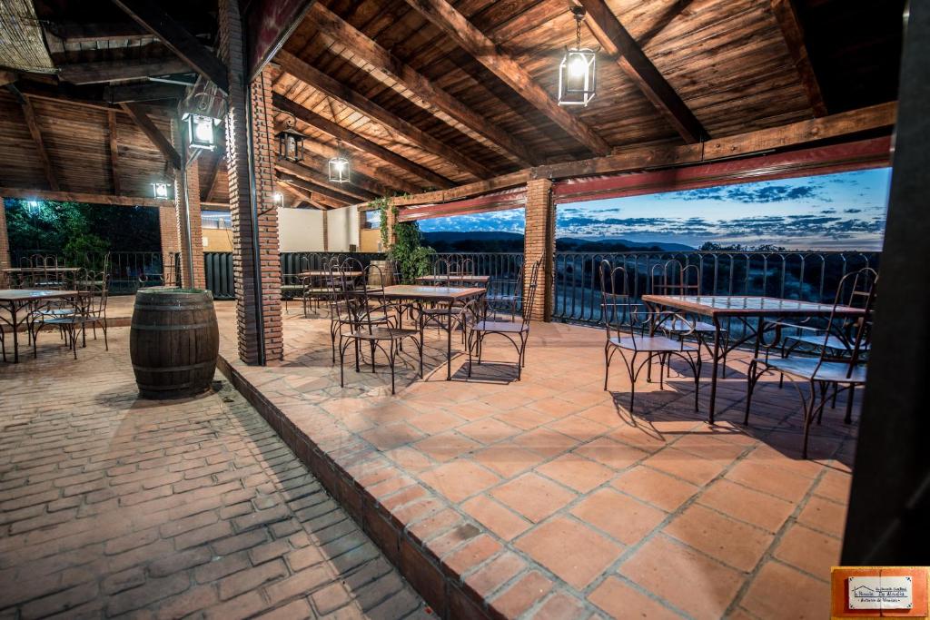 un patio con mesas y sillas y vistas al océano en La Posada de Alcudia, en Brazatortas