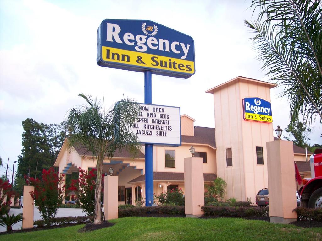 Una posada y suites de autopista firman frente a un edificio en Regency Inn and Suites Humble, en Humble