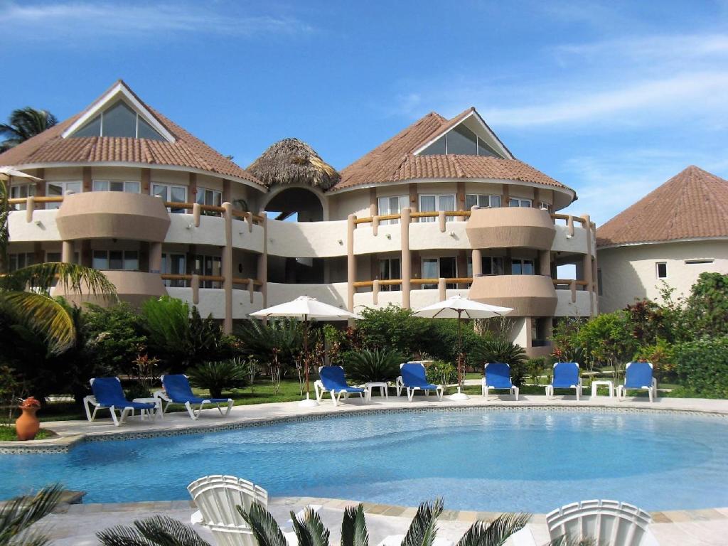 a resort with a pool and chairs and a building at Luxury apartment with ocean view at the beach in Cabarete