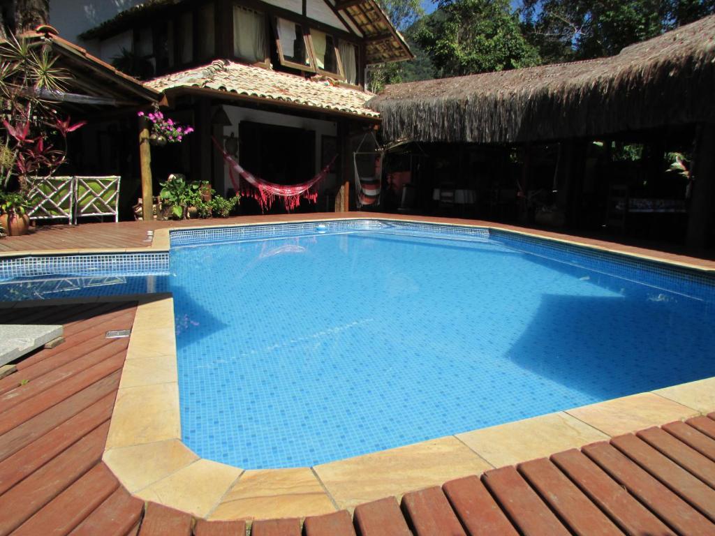 a large swimming pool on a deck with a house at Pousada Bawa in Ubatuba