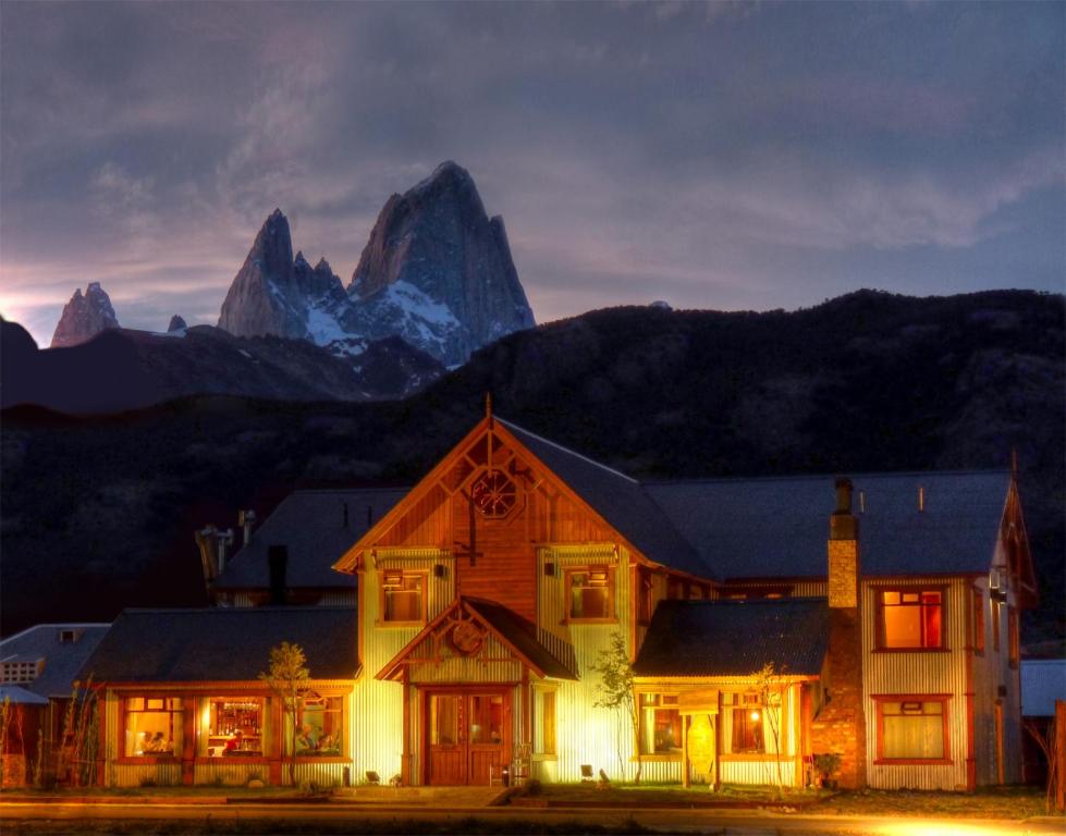 una casa con una montaña en el fondo en Hosteria Senderos en El Chaltén