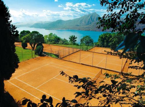 einen Tennisplatz vor einem Wasserkörper in der Unterkunft Park Hotel Jolanda in San Zeno di Montagna