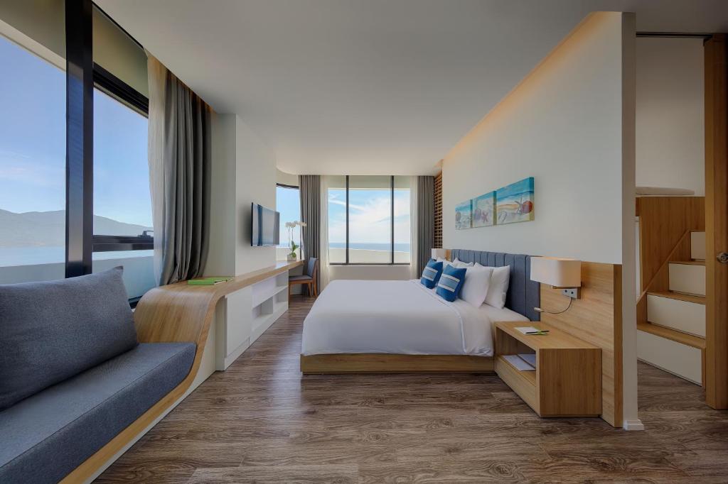 ein Hotelzimmer mit einem Bett und einer Couch in der Unterkunft Belle Maison Parosand Da Nang Hotel -managed by H&K Hospitality in Đà Nẵng
