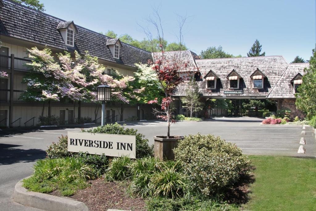 un letrero de una posada universitaria frente a un edificio en Riverside Inn, en Grants Pass