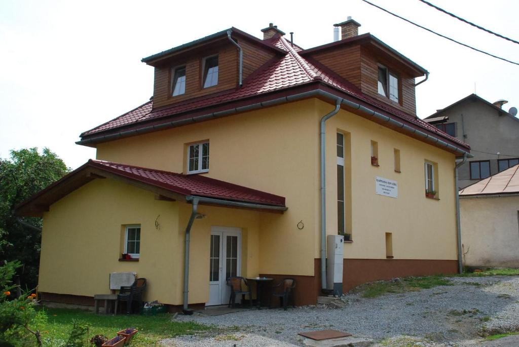 ein kleines gelbes Haus mit braunem Dach in der Unterkunft Apartmánový Dom Králiky in Králiky