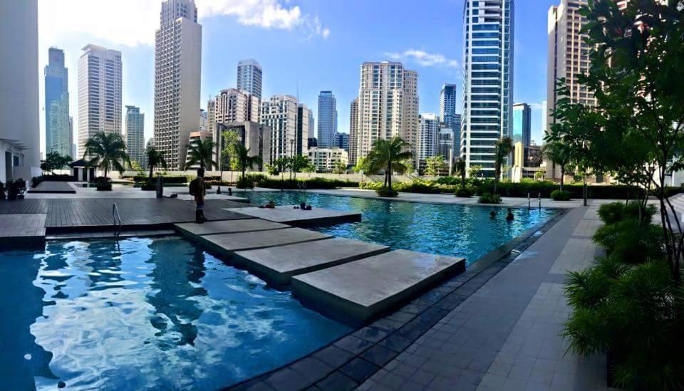 a pool with a city skyline in the background at Jazz Hunter Residence in Manila