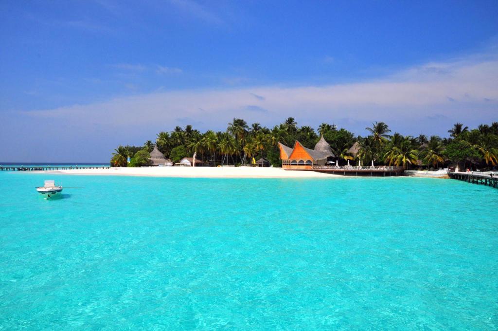 a view of an island with a boat in the water at Thulhagiri Island Resort & Spa in North Male Atoll