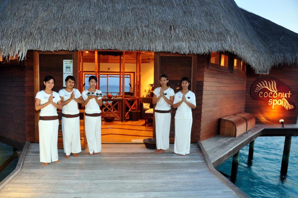 a group of women standing in front of a hut at Thulhagiri Island Resort & Spa in North Male Atoll