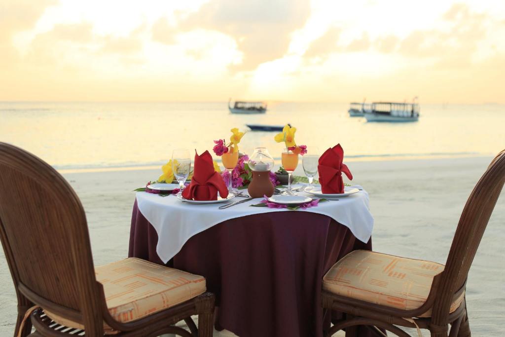 a table on the beach with a tableablish at Thulhagiri Island Resort & Spa in North Male Atoll