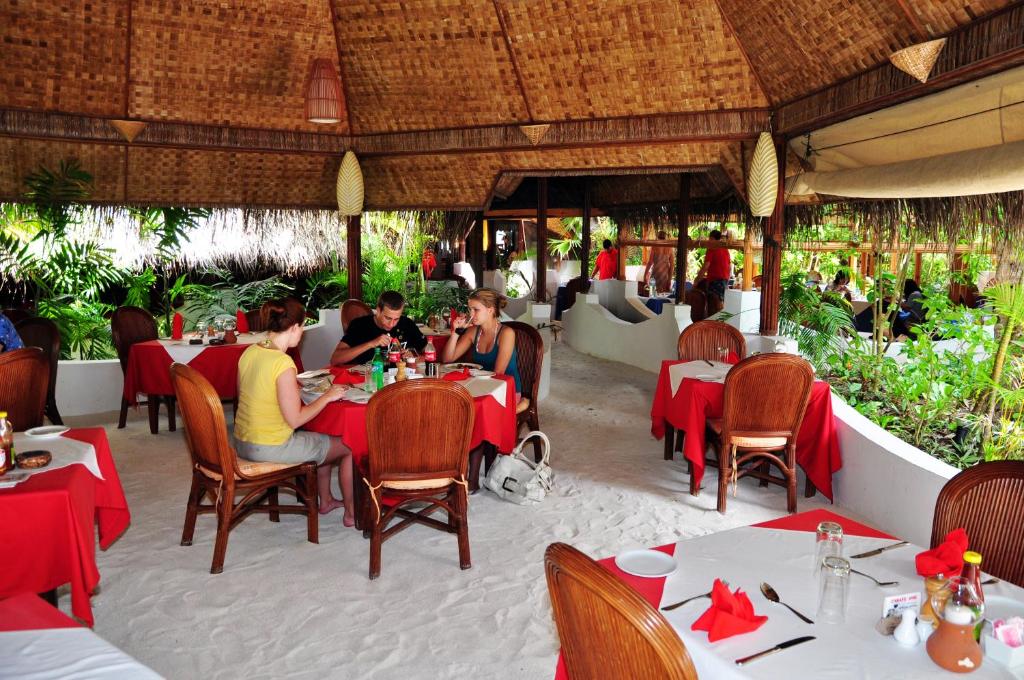a group of people sitting at tables in a restaurant at Thulhagiri Island Resort & Spa in North Male Atoll