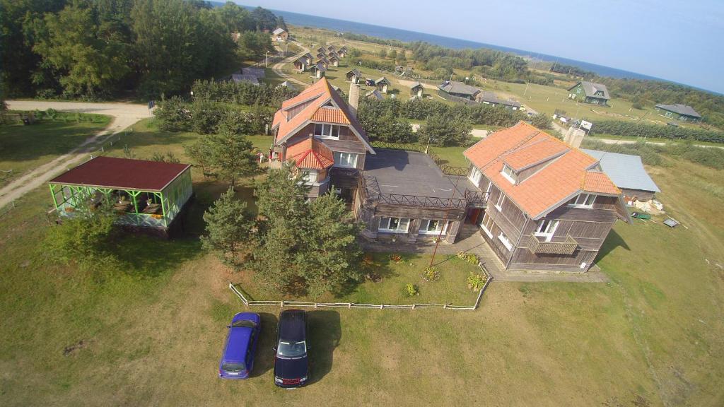 una casa grande con coches estacionados frente a ella en Viesu nams un kempings Papes Čakstes, en Pape