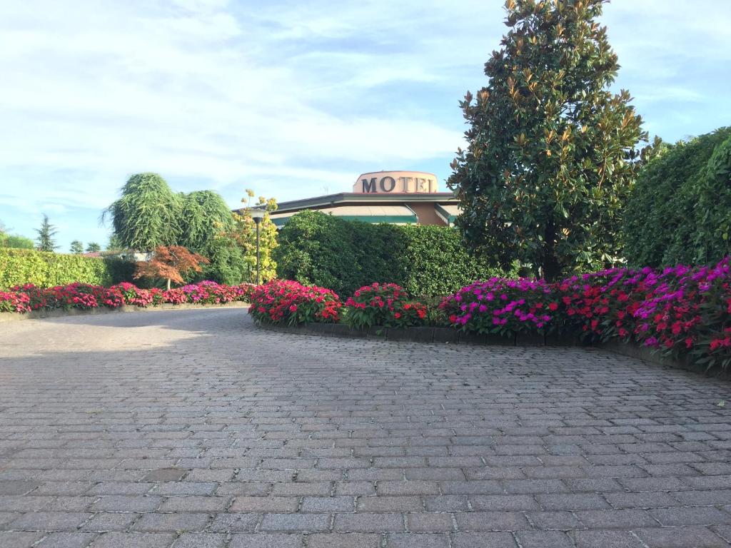 a garden of flowers with a building in the background at Hotel Motel Luna in Segrate