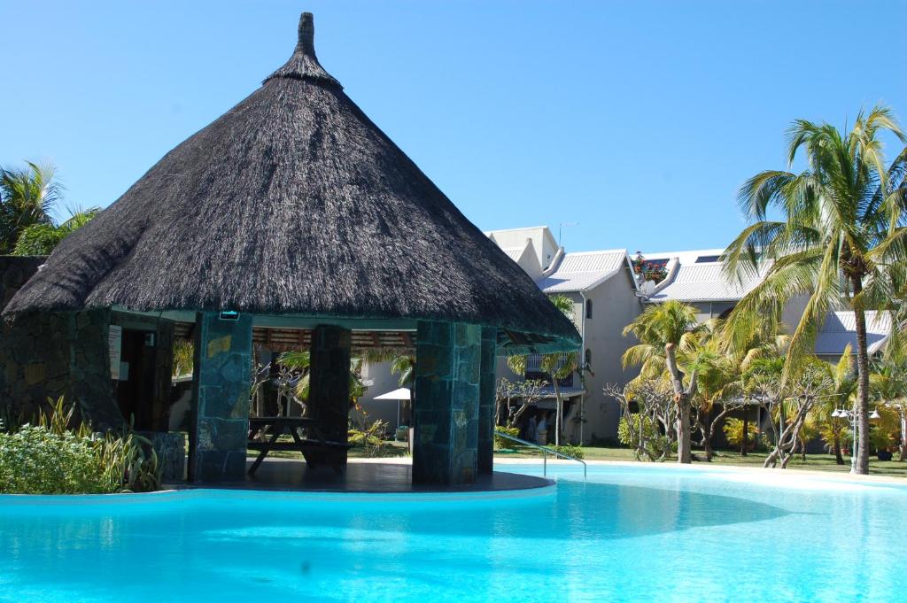 a hut next to a swimming pool at a resort at Kenville in Cap Malheureux